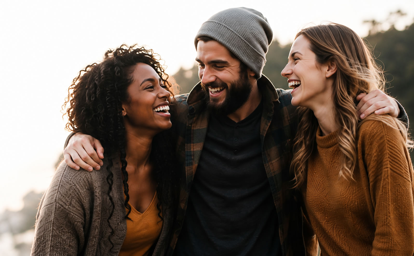 Three friends laughing together, arms around each other