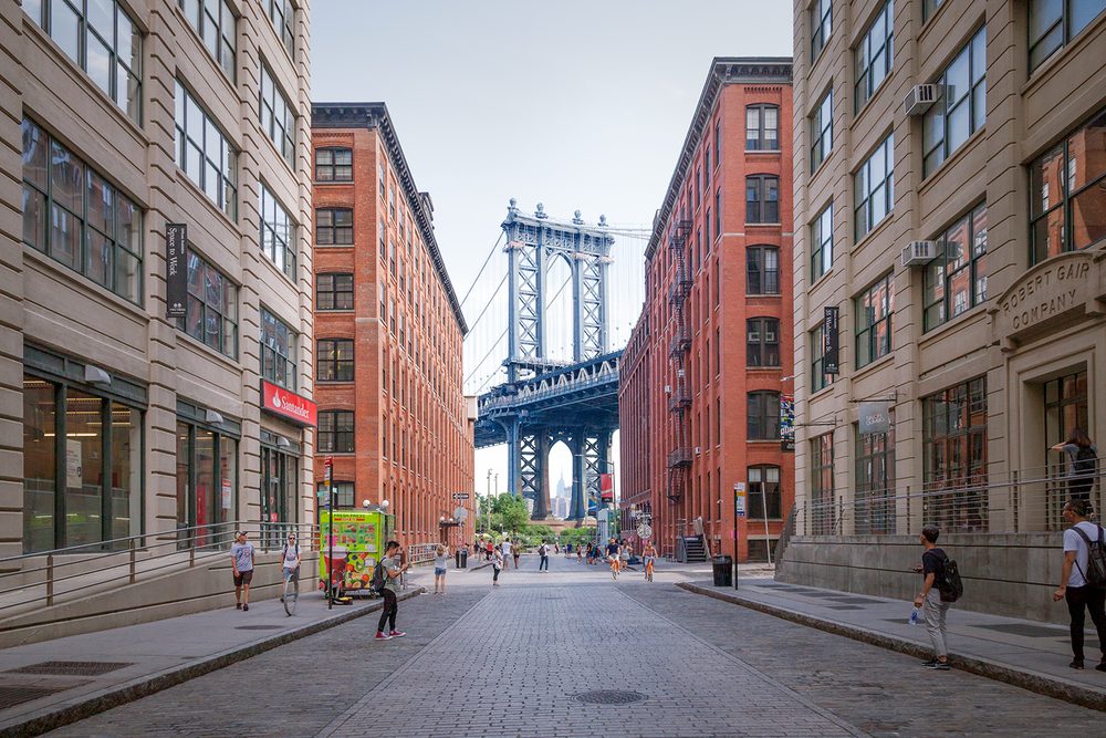 The Manhattan Bridge framed by the cobblestone streets and brick warehouses of DUMBO, Brooklyn